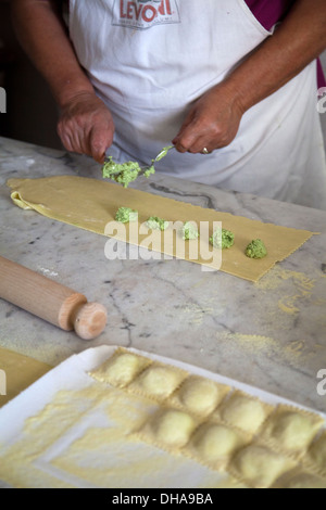 Frau Vorbereitung Ravioli Füllungen von Ricotta und Grüns Stockfoto