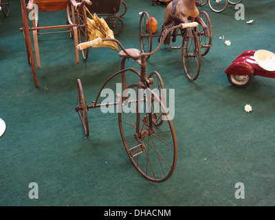 Dieses alte Kinderdreirad, ein Vintage-Spielzeug, repräsentiert das Design des frühen 20. Jahrhunderts im Kindertransport. Es handelt sich um ein nostalgisches Stück aus der Vergangenheit, das heute in einer Museumssammlung aufbewahrt wird. Stockfoto