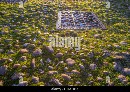 Gepflasterte Straße Elkington rechteckigen Schacht und Gras wachsen zwischen den Steinen im alten Teil des Roggens; East Sussex, England Stockfoto