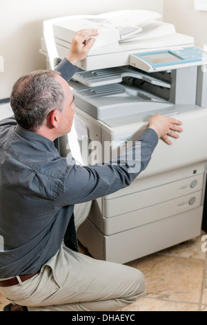 Business-Mann öffnen Fotokopie Maschine im Büro Stockfoto