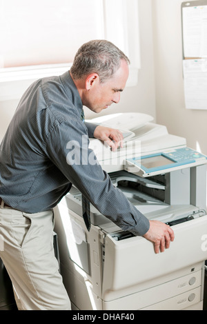 Business-Mann öffnen Fotokopie Maschine im Büro Stockfoto