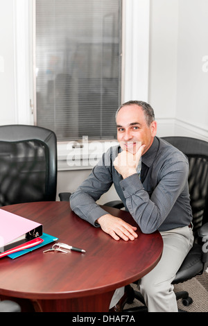 Applying Geschäftsmann suchen glücklich sitzt am Tisch im Büro, Tagungsraum Stockfoto
