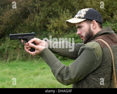 Junger Mann Pistolenschießen, Bude, Cornwall, UK Stockfoto