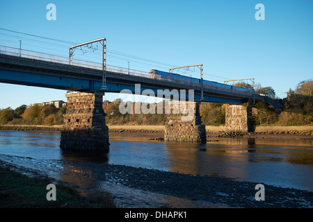 Personenzug auf der Eisenbahnbrücke überquert den Fluss Lune in Lancaster UK Stockfoto
