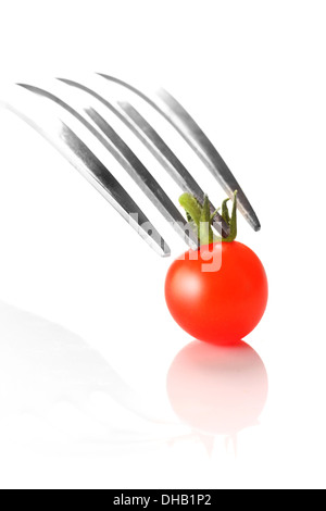 Eine kleine Cherry-Tomaten mit einer Gabel an Ihrem Platz gehalten. Stockfoto