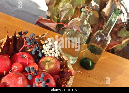 Rote Äpfel und Beeren in einem Korb auf Tisch Stockfoto