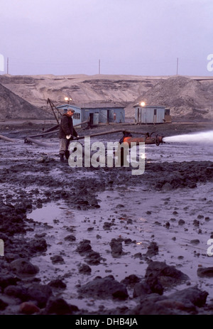 Workman sprüht ein Wasserwerfer auf den blauen Ton innerhalb der Tagebau Palmnicken Amber Mine an der Ostsee, Russland Stockfoto