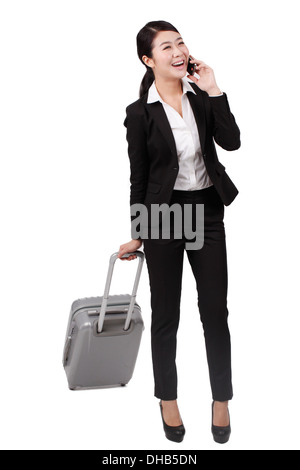 Geschäftsfrau mit einem Handy ziehen einen Koffer Stockfoto