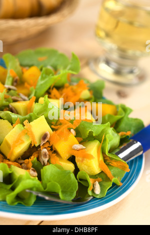 Frische und leichte vegetarische Salat aus Mango, Avocado, Möhren und Salat, bestreut mit gerösteten Sonnenblumenkernen Stockfoto