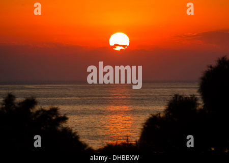 Die untergehende Sonne durch die Wolken über dem Mittelmeer Stockfoto