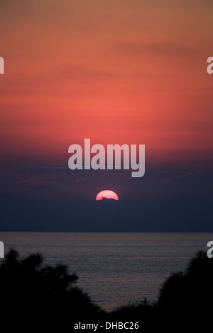 Die untergehende Sonne durch die Wolken über dem Mittelmeer Stockfoto