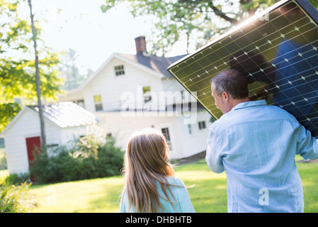 Ein Mann mit einem Solar-Panel für ein Gebäude im Bau. Stockfoto