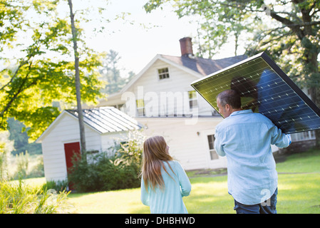 Ein Mann mit einem Solar-Panel für ein Gebäude im Bau. Stockfoto