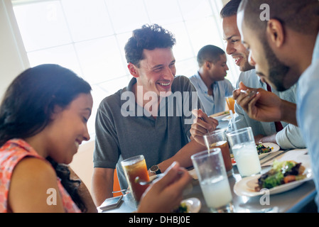 Eine Gruppe von Männern und Frauen in einem Café mit Getränken und genießen die Gesellschaft des anderen. Stockfoto