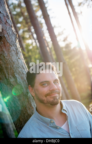 Ein Mann steht im Wald an einem See. Stockfoto