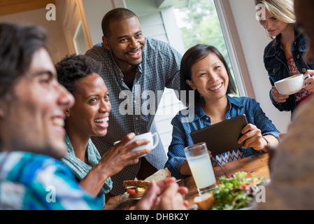 Eine Gruppe von Menschen, die in einem Café treffen. Verwenden digitale Tablets und Smartphones. Stockfoto