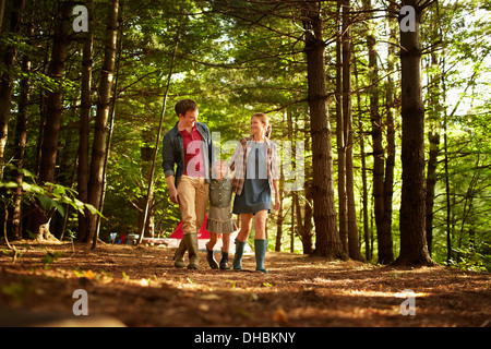 Drei Menschen, eine Familie zu Fuß im Wald am späten Nachmittag. Stockfoto