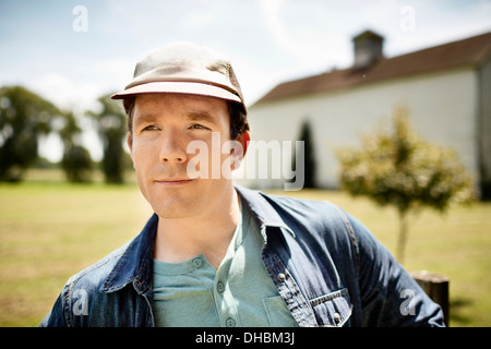 Ein Mann in eine Baseball-Cap auf einem Bio-Bauernhof im Staat New York. Stockfoto