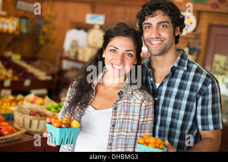 Ein Bauernhof, Anbau und Verkauf von Bio-Gemüse und Obst. Ein Mann und eine Frau zusammen arbeiten. Stockfoto