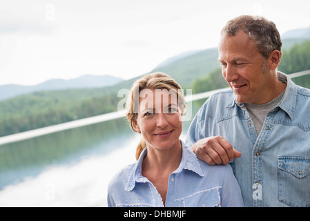 Ein älteres paar tatenlos einem Seeufer. Stockfoto