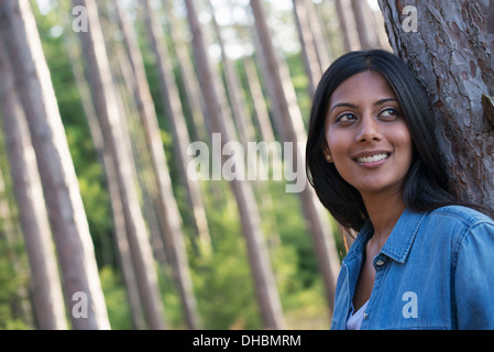 Bäume am Ufer eines Sees. Eine Frau, die im Schatten stehen. Stockfoto