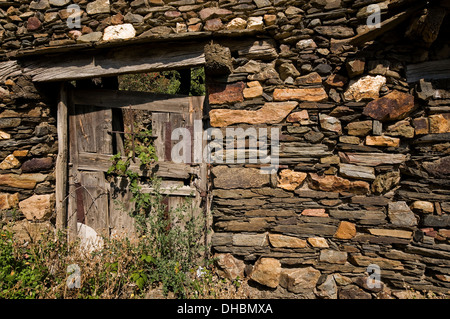 Alte Holztür. Altes Haus in einem Dorf links Stockfoto