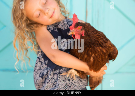 Ein junges Mädchen, ein Huhn auf dem Arm halten. Stockfoto