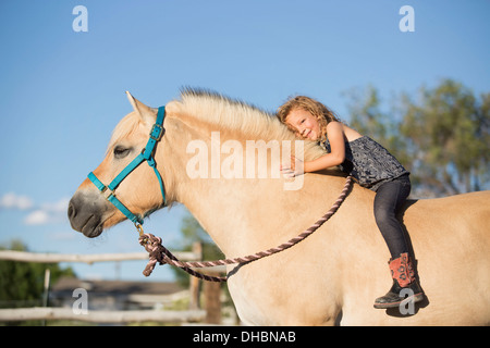 Ein junges Mädchen auf einem Pferd sitzen. Stockfoto
