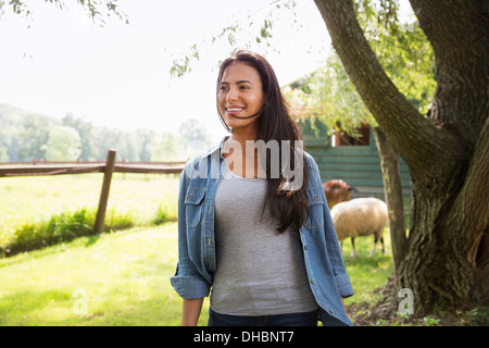 Ein Bio-Bauernhof in den Catskills. Eine Frau in einer Koppel mit einem Schaf. Stockfoto