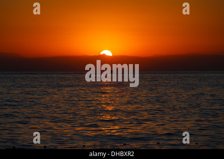 Die untergehende Sonne durch die Wolken über dem Mittelmeer Stockfoto