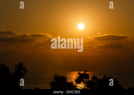 Die untergehende Sonne durch die Wolken über dem Mittelmeer Stockfoto