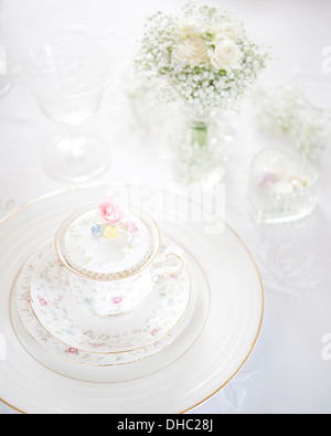 Eine Hochzeit Frühstück Gedeck mit China Teetasse, Cupcake und Vase mit weißen Blumen Stockfoto