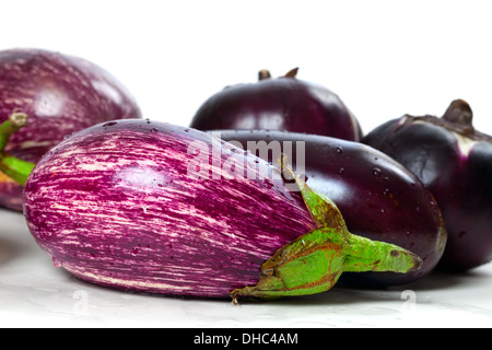 Verschiedene Sorten von Auberginen auf nassen weißen Hintergrund Stockfoto