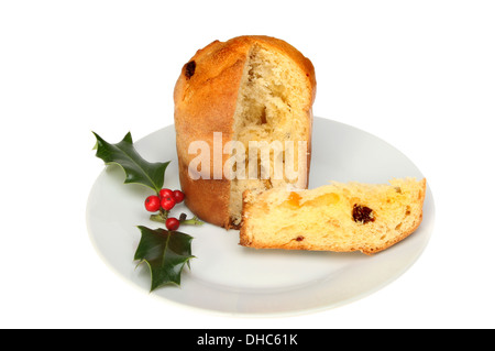 Panettone auf einem Teller, dekoriert mit Holly isoliert gegen weiß Stockfoto