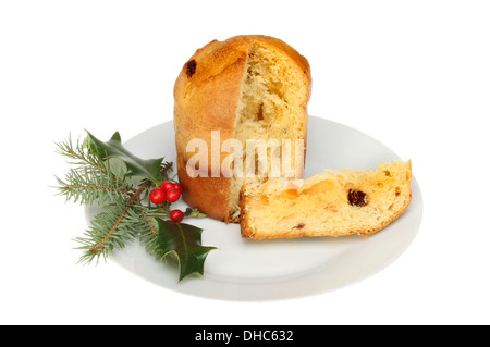 Panettone auf einem Teller, dekoriert mit Holly und Tannennadeln isoliert gegen weiß Stockfoto