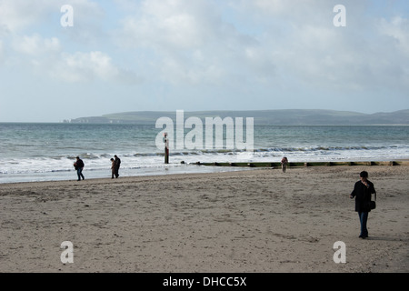 Spaziergänger am Strand von Bournemouth mit Purbeck Hills im Hintergrund Stockfoto