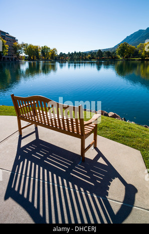 Verwitterte Holzbank mit Blick auf Cheyenne See, The Broadmoor, historische Luxus-Hotel und Resort, Colorado Springs, Colorado, USA Stockfoto