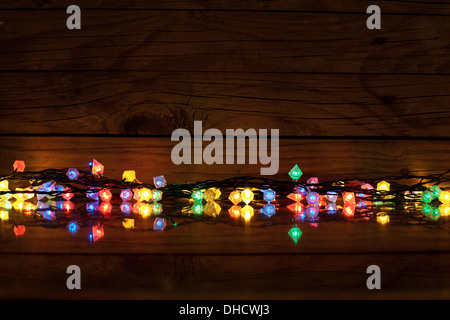 Weihnachtsbeleuchtung auf dunklem Holz mit Textfreiraum, dekorative Girlande Stockfoto