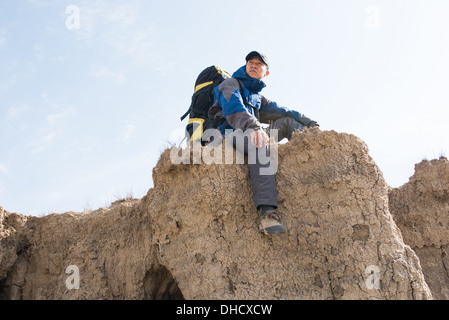 Sitzen auf einer Klippe Wanderer ruht. Asiatische Jugend Stockfoto