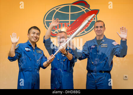 Expedition 38 Flugingenieur Koichi Wakata der Japan Aerospace Exploration Agency, links, Sojus-Kommandant Mikhail Tyurin von Roskosmos, und Flugingenieur Rick Mastracchio der NASA, rechts, Lächeln und war, wie sie eine olympische Fackel halten, die mit ihnen zur internationalen Raumstation ISS, während einer Pressekonferenz im Hotel Kosmonaut in Baikonur, Kasachstan am 6. November 2013 geflogen werden wird. Start der Sojus-Rakete ist geplant für November 7 und schicken Tyurin, Mastracchio, Wakata auf einer sechsmonatigen Mission an Bord der internationalen Raumstation ISS. Obligatorische Credit: Bill Ingalls / NASA V Stockfoto