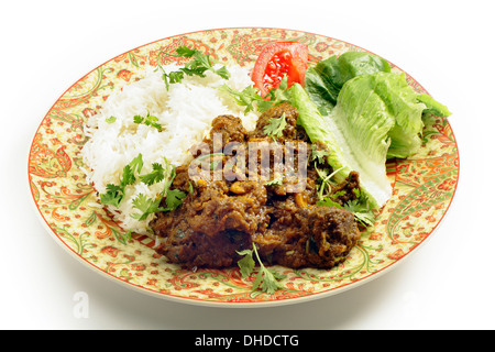 Nordindischen oder pakistanischen Stil Bhuna Ghosht, eine ziemlich trockene Lamm-Curry mit Reis und Salat serviert Stockfoto