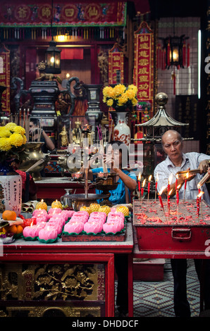 Ein Mann und Frauen leichte Räucherstäbchen während Chinese New Year Feiern, Sze Ya Tempel, Chinatown, Kuala Lumpur, Malaysia Stockfoto