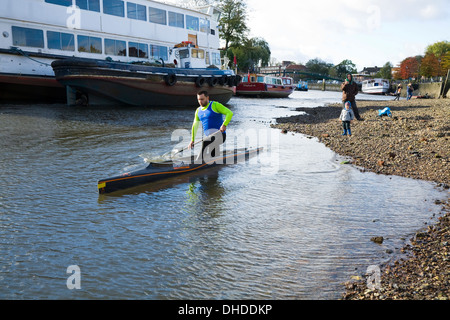 Kanuten im Kanu / Kajak Boot auf der Themse bei sehr Ebbe in Twickenham, Middlesex. VEREINIGTES KÖNIGREICH. Stockfoto