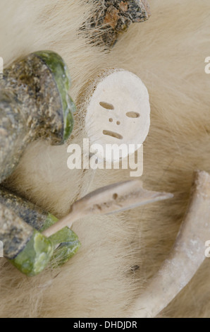 Kanada, Nunavut, Qikiqtaaluk, Cape Dorset. Speckstein Schnitzen auf Eisbär Fell. Stockfoto