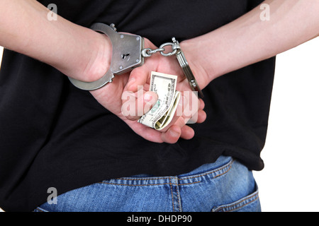 Handschellen in Händen mit Geld Stockfoto