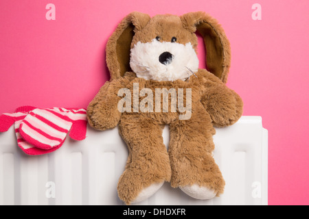 Ein rosa Kinderzimmer mit ein Teddybär und ein paar Handschuhe auf einem Heizkörper platziert. Stockfoto