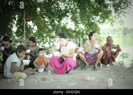 Mae Sot, Tak, Thailand. 7. November 2013. Burmesische Flüchtlinge und Müllsammler Essen auf der Müllhalde von Mae Sot. Tingkaya auch bekannt als die Stadt Müll eine Fläche etwa die Größe eines Fußballstadions machen die armen Bewohner einen Lebensunterhalt mit dem Verkauf von wiederverwertbaren Materialien wie Draht, Metall, Glas, Kunststoff. Sie häufen Bewohner überleben durch den Verzehr von Essensresten und schlafen in der gleichen rauen Umgebung ist ein Nährboden für Bakterien und Krankheiten. Bildnachweis: Rohan Radheya/ZUMA Wire/ZUMAPRESS.com/Alamy Live-Nachrichten Stockfoto