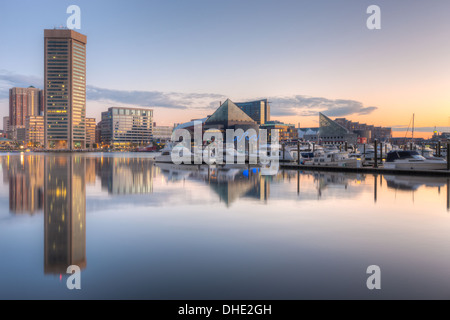 Skyline von Baltimore in der Morgendämmerung, einschließlich des World Trade Center und National Aquarium, spiegelt sich in den Gewässern der Innenhafen. Stockfoto