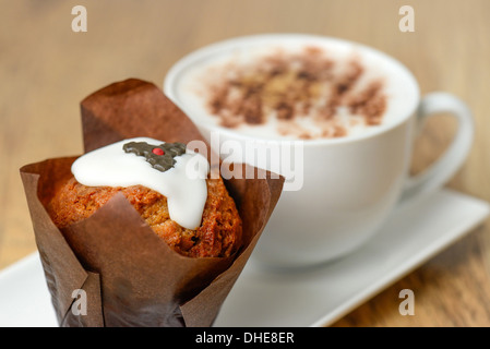 Cupcake mit einem dekorierten Plumpudding-Design und einen Cappuccino Kaffee - Studio mit einer geringen Schärfentiefe erschossen Stockfoto