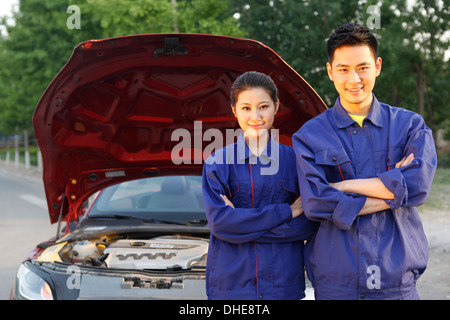 Junger Mann und junge Frau Auto reparieren Personal Stockfoto